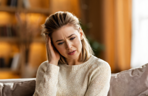 Woman in Covington, LA holding the side of her head with ear pain from an ear infection
