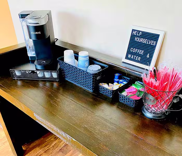 Complimentary coffee and water station in the Total Health Urgent Care waiting area in Covington, LA